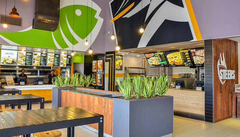 Food court store fronts and decor finished with wood paneling that is finished using a hardwax oil wood finish.