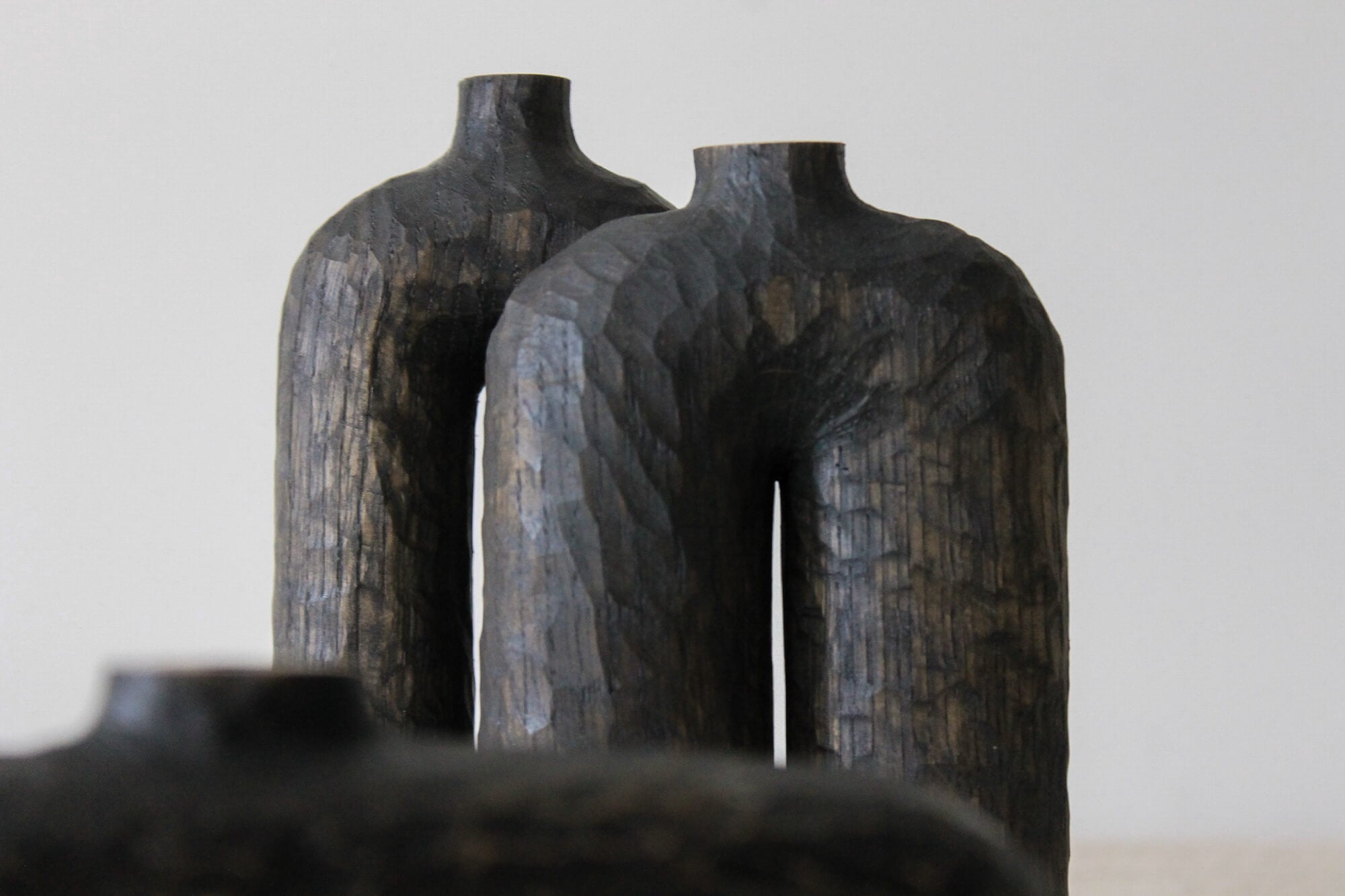 Two modern hand-carved wooden vases with curved elements and organic carved details. The vases were finished with Rubio Monocoat Oil Plus 2C hardwax oil finish.