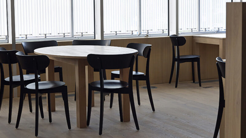 Natural wood table and floors in an office.