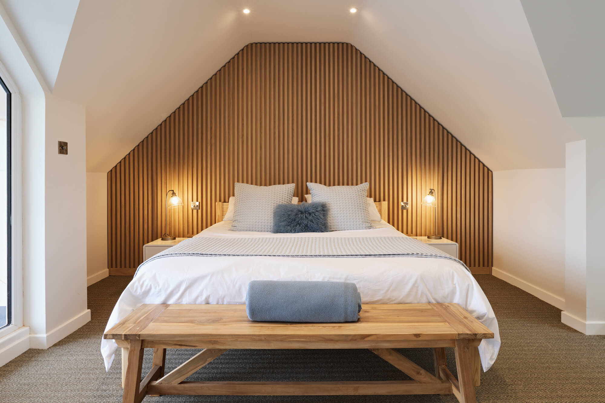 A master bedroom with a white oak slatted millwork accent wall finished with an interior wood finish, Rubio Monocoat Oil Plus 2C. This is amazing modern bedroom design inspiration!