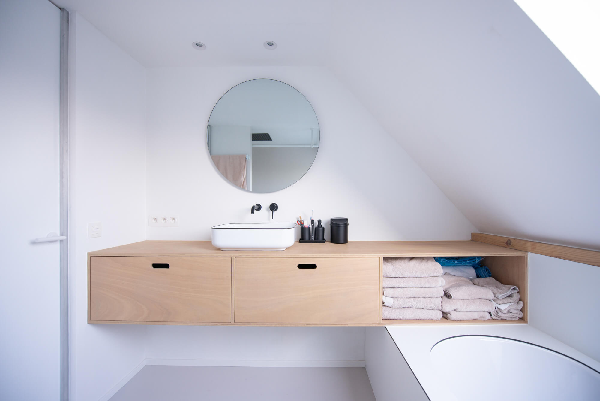 A floating bathroom vanity finished with Rubio Monocoat Oil Plus 2C hardwax oil for interior wood surfaces and in a renovated rectory in Belgium, blending traditional and modern elements, a prime example when it comes to renovating a historic structure.