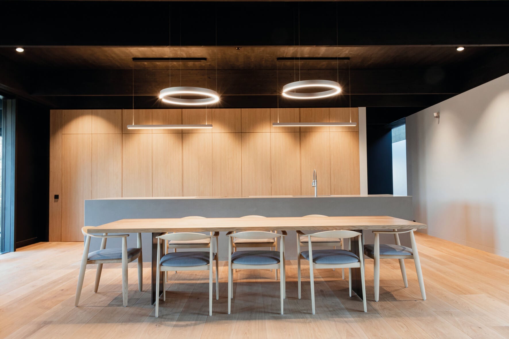 Stunning dining room features wooden walls and furniture finished with Rubio Monocoat.