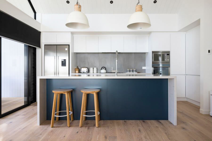 Light kitchen with white cabinets and wide plank hardwood floors.