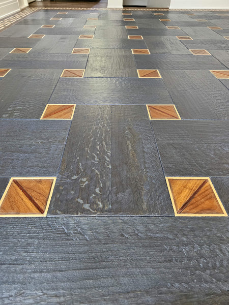 Close up of a white oak basketweave patterned floor finished in a blue hue. 