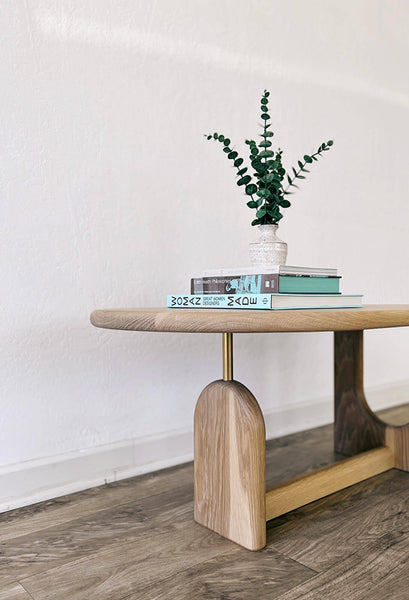 A side view of the inverse coffee table featuring coffee table books and a decorative plant.