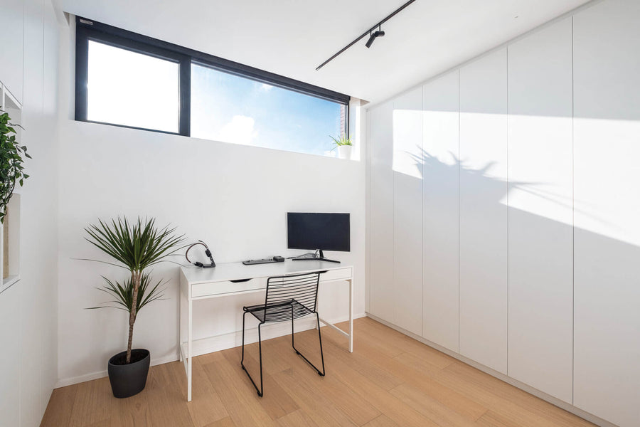 Bright home office with a desk sitting on wood flooring that is finished with a natural oil wood finish.