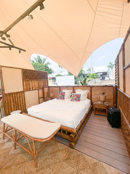 A bedroom set in an outdoor tradeshow booth made from recycled materials.