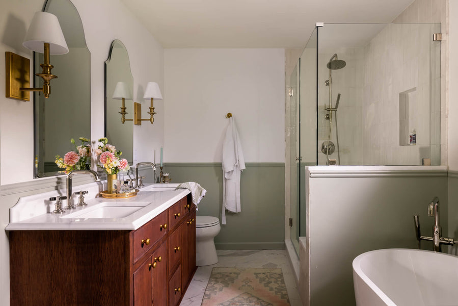 A double vanity made from white oak featuring a light colored marble countertop.