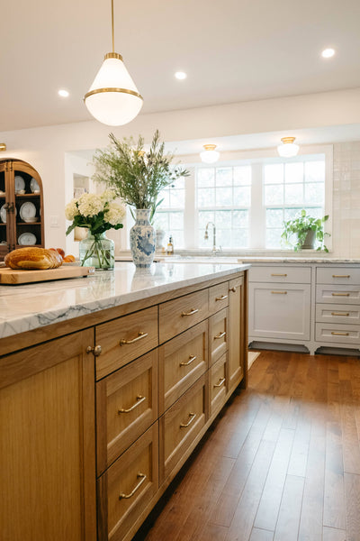 A custom-built white oak island with brass hardware finished using Rubio Monocoat Oil Plus 2C Pure.