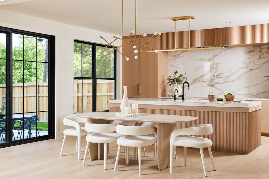 A light and bright white oak kitchen with reeded detailing, modern light fixtures and brass hardware.